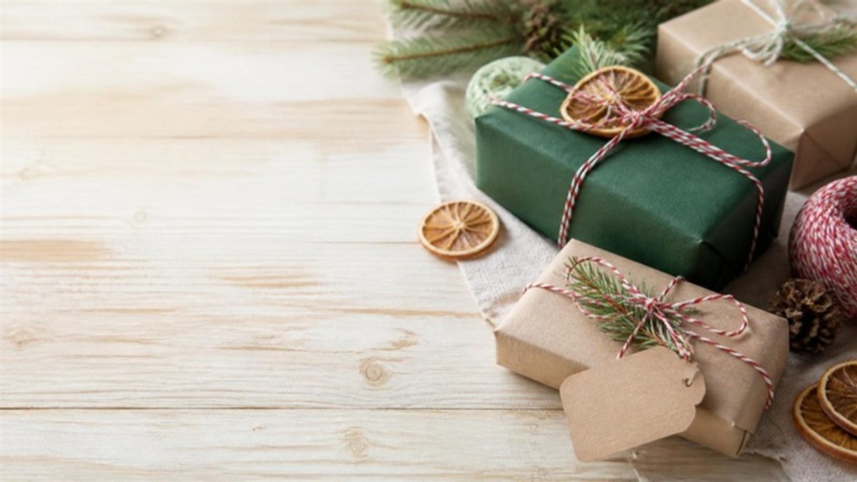 Gifts wrapped in kraft and green paper with twine, pine and dried orange slices